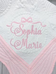 a pink and white quilt with the word sophiia marie on it