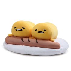 two yellow stuffed animals sitting on top of a hot dog