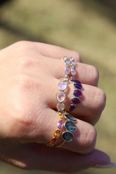 Okay everyone needs one of these in their lives. I'm dead serious. It is one of the prettiest rings ever and it goes with everything. This ring features a variety of different oval-shaped sapphires ranging in color from orange to violet set in 18K solid gold. This ring can also be made in certain colors/patterns. Please get in touch with us for custom orders at marena@jewelsbymarena.com. Please allow up to 3 weeks for shipping once order is placed as each piece is handmade to order. Oval Multi-stone Sapphire Gemstones, Oval Sapphire Gemstone With Multi-stone Detail, Multicolor Oval Sapphire Ring For Anniversary, Multicolor Oval Sapphire Ring, Oval Sapphire Multi-stone Gemstones, Multicolor Oval Amethyst Ring With Gemstone Accents, Multicolor Oval Amethyst Gemstone Ring, Purple Multi-stone Sapphire Ring, Oval Faceted Sapphire Ring Fine Jewelry