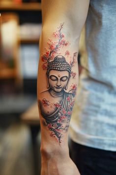 Buddha tattoo with cherry blossoms on a person's forearm. Buddha Lotus Flower Tattoo, Buddha Symbol Tattoo, Buddhist Symbol Tattoos, Buddha Tattoo Ideas, Buddha Tattoo Sleeve, Buda Tattoo, Meditation Tattoo, Tattoo Design For Women, Buddhist Tattoo