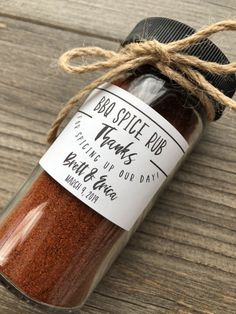 a jar filled with red spice sitting on top of a wooden table next to a string