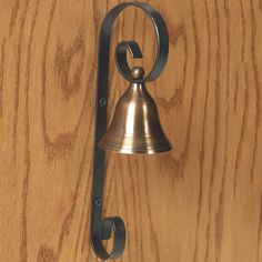 a metal bell mounted to the side of a wooden wall