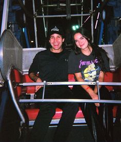 a man and woman sitting on a public transit bus at night with their arms around each other