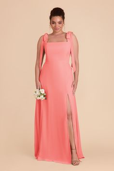 a bridesmaid in an orange gown with one side slited and flowers on the side