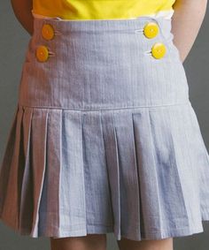 a woman wearing a skirt with buttons on it