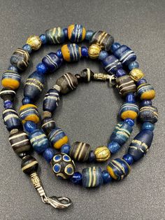 Ancient blue color roman glass beads from ancient roman empire . The origin of this beads from Afghanistan . some Wax gold plated beads used as counter beads we provide fast and free shipping to our customers by which can get the items by 7 maximum working days Traditional Czech Glass Polished Beads, Artisan Single Strand Gold Beads, Artisan Gold Single Strand Beads, Traditional Single Strand Gold Beads, Traditional Gold Single Strand Beads, Large Glass Beads For Jewelry Making, Artisan Glass Beaded Necklace With Spacer Beads, Bohemian Single Strand Gold Beads, Single Strand Glass Beaded Necklaces With Round Beads