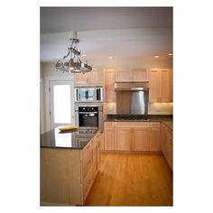 a kitchen with wood floors and stainless steel appliances