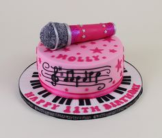 a pink cake with musical notes and a microphone