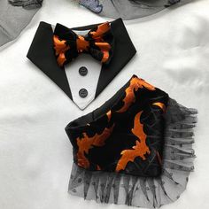 an orange and black bow tie on top of a white shirt with tuxedo