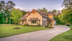 a large house in the middle of a lush green field