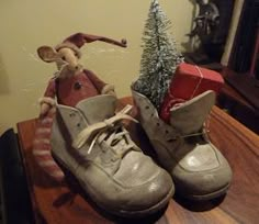 a pair of shoes sitting on top of a wooden table next to a christmas tree