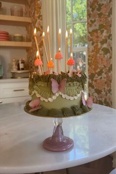 a birthday cake with lit candles sitting on a table