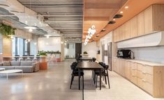 an office building with tables, chairs and couches in the middle of the room