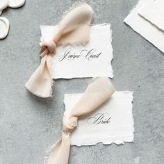 two pieces of paper with ribbons on them