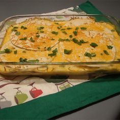 a casserole dish with cheese and green garnish