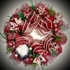 a red and green christmas wreath with ornaments