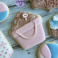 decorated cookies with handbags and purses sitting on top of a wooden table next to each other