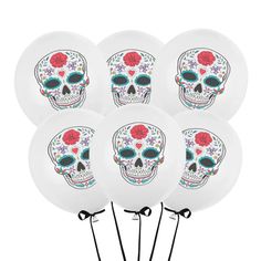 six white balloons with skulls and flowers on them