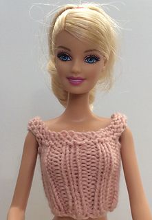 a barbie doll wearing a pink knitted top