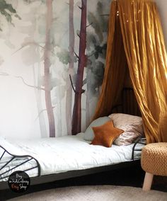 a bed with a canopy in front of a forest mural