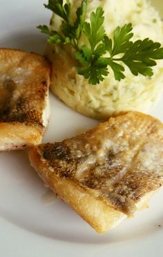 two pieces of toasted bread on a plate with mashed potatoes and parsley