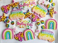 decorated cookies on a plate with happy birthday messages and rainbows in the middle,