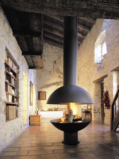 a fireplace in the middle of a room filled with books