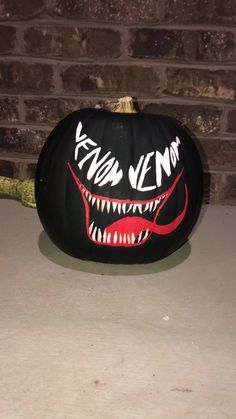 a black pumpkin decorated with an image of a monster's mouth and fangs on it