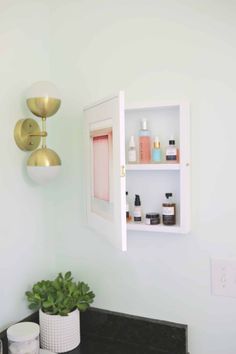 a bathroom sink with a mirror above it and shelves on the wall next to it