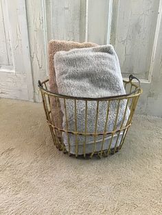 two towels are sitting in a basket on the floor