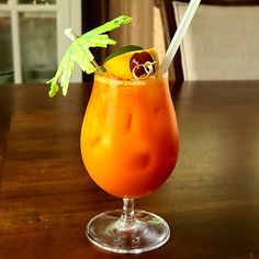 an orange drink sitting on top of a wooden table