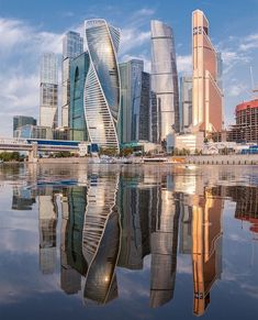 the skyscrapers are reflected in the still water