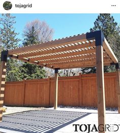 a wooden pergola in the middle of a yard