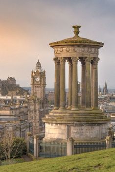 an old building with two columns and a clock tower in the middle of it's city