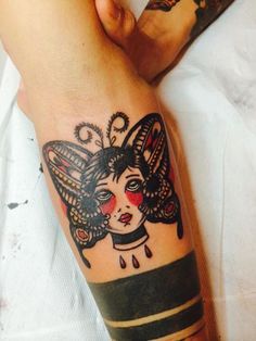 a woman's arm with a butterfly tattoo on it and a lady face in the middle