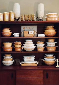 a wooden shelf filled with lots of dishes