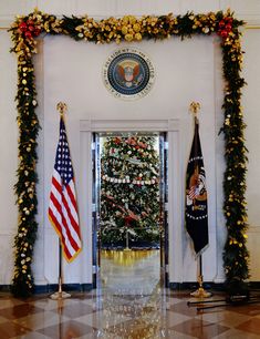 the white house decorated for christmas with wreaths and flags