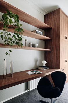 a black chair sitting in front of a wooden shelf