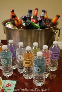 there are many bottled water bottles on the table next to a bowl of lemonade