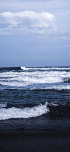 the ocean waves are rolling in to shore