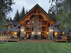 a large wooden house in the middle of a forest with lots of trees around it