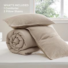 the comforter is folded up on top of the bed with two pillow shampoos