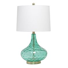 a green glass table lamp with a white shade