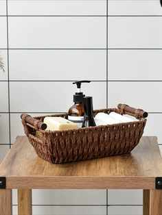 a wooden table topped with a brown basket filled with soap and lotion