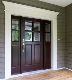 the front door of a house with wood flooring and two sidelights on either side