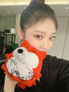 a woman holding up a stuffed animal in front of her face