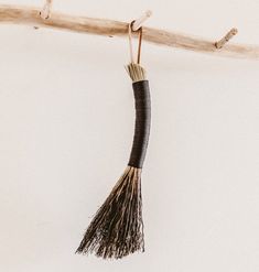 a long tassel hanging from a wooden branch