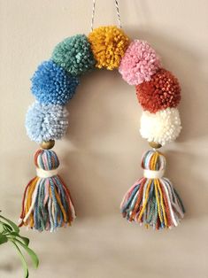 This listing is for a pom pom rainbow wall hangingmeasuring roughly 7wide and 9high (not including the hanging cordin a Sedona inspired color paletteColors includeCreamclear bluegoldgreen lagoonpetuniapersimmon and soft roseEach rainbow is made with handmade yarn pom pomsfastened together with wire and twine to hold its shapeand completed with wooden beads and tasselsOne of my favorite pieces to makethese pom pom rainbow wall hangings with rainbow tassels bring a touch of whimsy to decorate nur Yarn Storage Michaels Stores, Yarn Rainbow Wall Hanging, Pom Pom Diy Crafts, Pom Pom Yarn Crafts, Pom Pom Rainbow Craft, Diy Pom Pom Decor, Pom Pom Gifts, Pom Pom Wall Decor, Pompom Diy Ideas