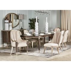 a dining room table with chairs and vases on top of it in front of a mirror