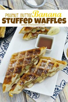 some waffles are sitting on a white plate with syrup and bananas in the background